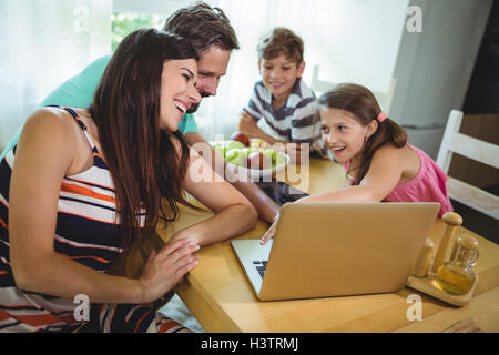 Family using  laptop at dinning table Stock Photo