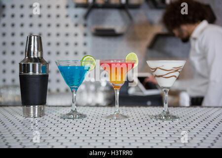 Various cocktails drinks and cocktail shaker on a bar counter Stock Photo