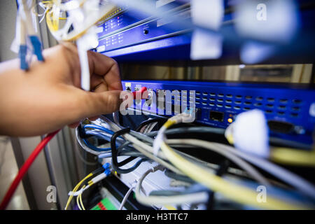 Technician fixing patch cable in a rack mounted server Stock Photo