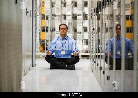 Technician meditating in hallway Stock Photo