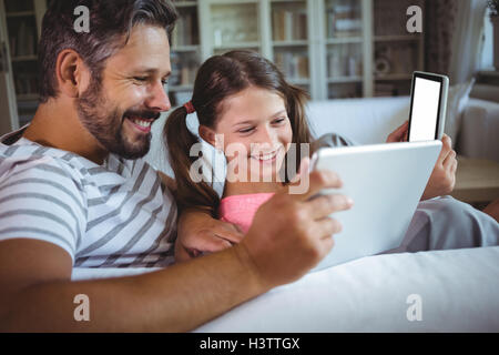 Happy father and daughter using digital tablet in living  room Stock Photo