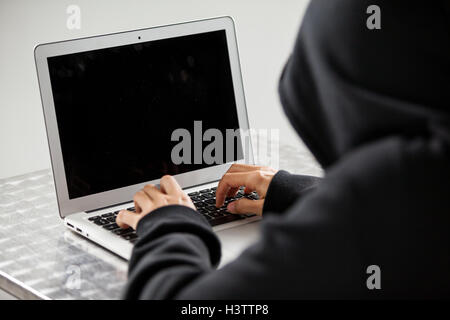 Hacker using a laptop Stock Photo