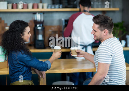 Smiling young couple having coffee in cafe Stock Photo