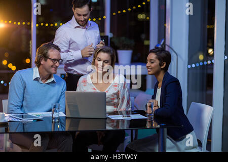 Businesspeople having discussion over laptop Stock Photo