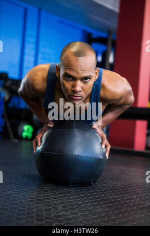 Young man using exercise ball in gym Stock Photo