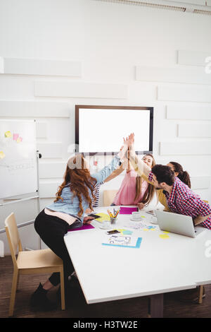 Happy executives giving high-five in meeting at creative office Stock Photo