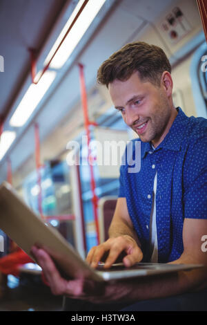 Handsome man using laptop in train Stock Photo