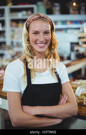 Smiling waitress with arms crossed Stock Photo - Alamy