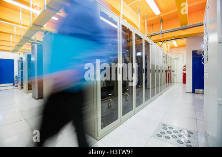 Technician walking in server room Stock Photo