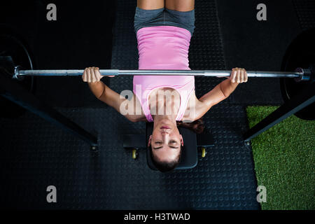 High angle view of athlete holding barbell while lying on bench press Stock Photo