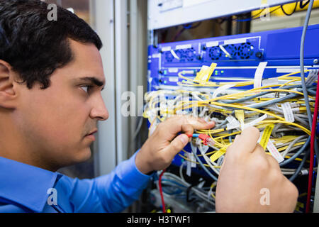Technician checking cables in a rack mounted server Stock Photo
