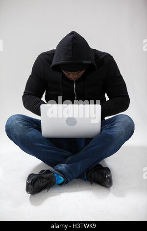 Hacker using a laptop Stock Photo