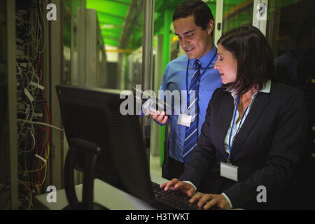 Technicians using digital cable analyzer while working on personal computer Stock Photo