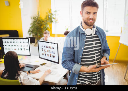 Portrait of happy executive using digital tablet at creative office Stock Photo