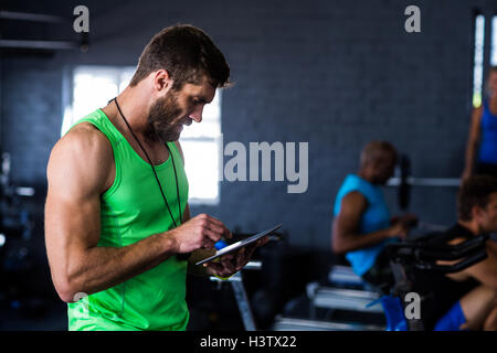 Hipster man using tablet in gym Stock Photo