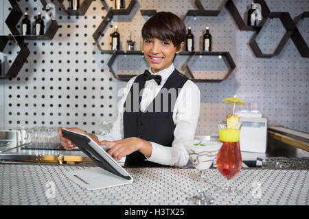 Waitress using digital tablet in bar counter Stock Photo