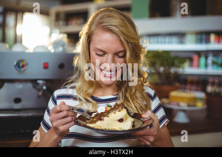 Smiling woman eating dessert in cafe Stock Photo