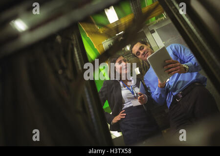 Technicians using digital tablet while analyzing server Stock Photo