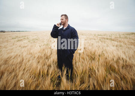Farmer talking on mobile phone in the field Stock Photo