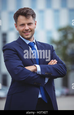 Portrait of handsome businessman standing with arms crossed isolated on ...