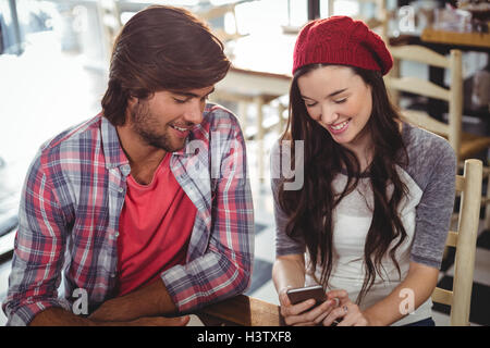 Smiling man and woman using mobile phone Stock Photo