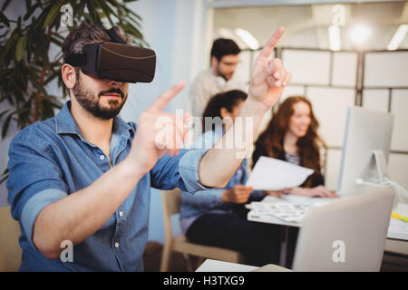 Creative businessman gesturing while using virtual reality headset Stock Photo