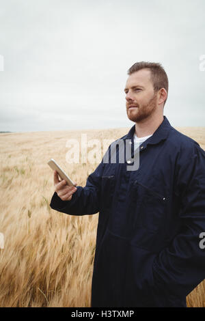 Farmer using mobile phone in the field Stock Photo