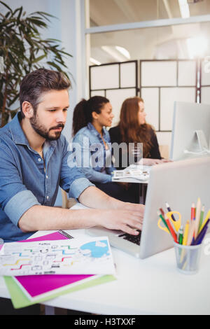 Creative business people using technologies at desk Stock Photo