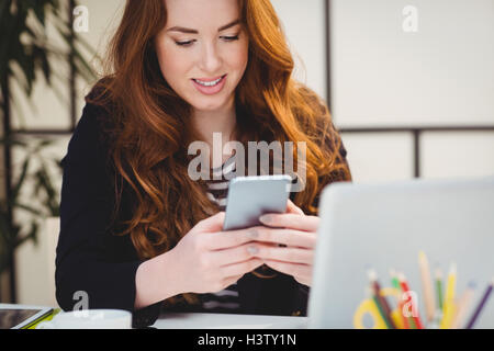 Happy woman using cellphone at creative office Stock Photo