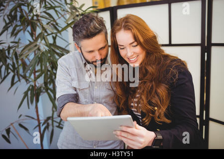 Happy businesswoman with colleague using digital tablet Stock Photo