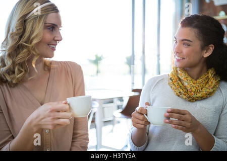 Female friends sitting together and having coffee Stock Photo
