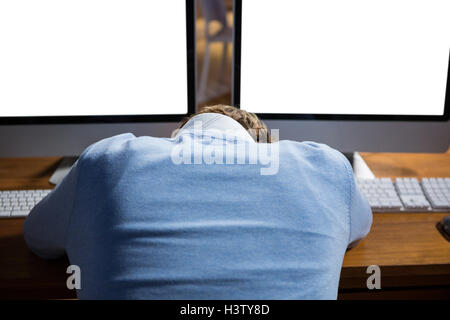 Businessman sleeping on desk while working in office Stock Photo