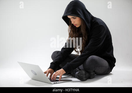 Hacker using a laptop Stock Photo