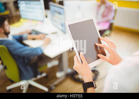 Businesswoman using tablet computer at creative office Stock Photo