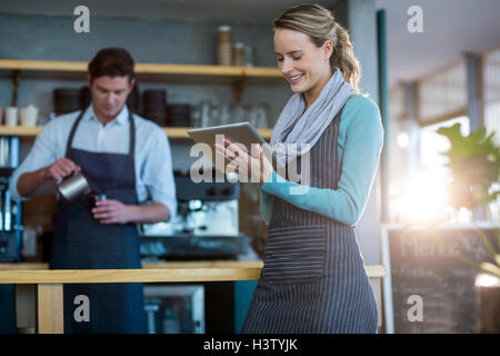 Waitress using digital tablet at counter Stock Photo