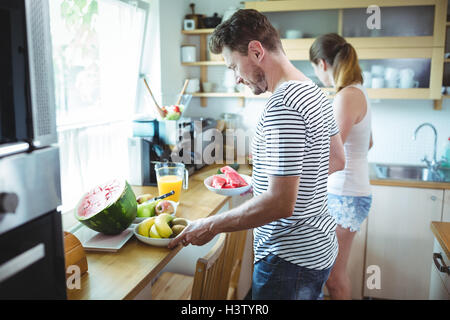 Couple preparing breakfast with fruits Stock Photo