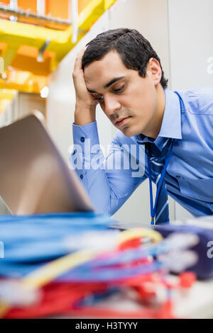Stressed technician using laptop Stock Photo