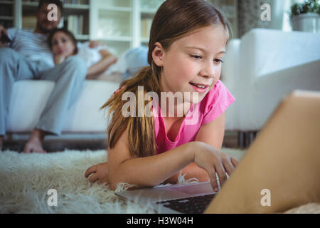 Girl lying on the floor and using laptop Stock Photo