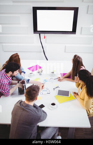 High angle view of business people watching at television in creative office Stock Photo