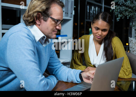 Business executives discussing over laptop Stock Photo