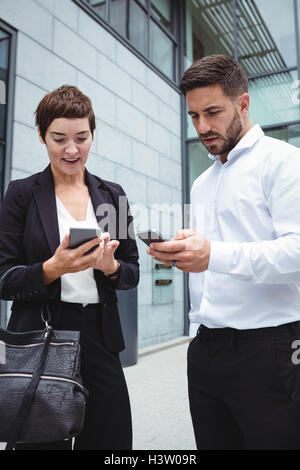 Businesspeople using mobile phone Stock Photo