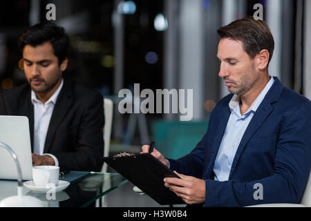 Businessman writing on clipboard Stock Photo