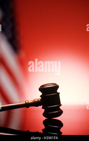 GAVEL RESTING ON REFLECTIVE BENCH SURFACE WITH AMERICAN FLAG IN BACKGROUND Stock Photo