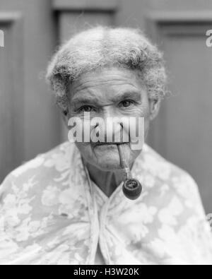 1940s PORTRAIT OF ELDERLY WOMAN LOOKING AT CAMERA SMOKING A PIPE HAVANA CUBA Stock Photo