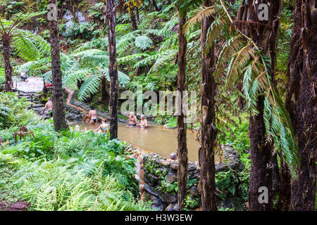 People enjoy bath in natural thermal pools of Caldeira Velha near Ribeira Grande town, Sao Miguel island, Azores, Portugal Stock Photo