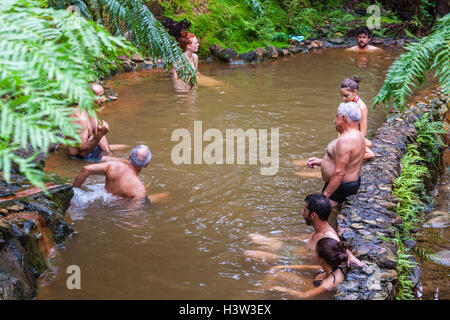 People enjoy bath in natural thermal pools of Caldeira Velha near Ribeira Grande town, Sao Miguel island, Azores, Portugal Stock Photo