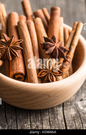 Cinnamon sticks and anise stars in wooden bowl. Stock Photo