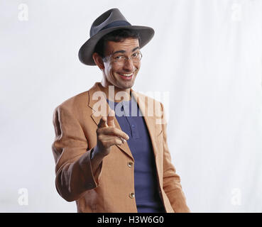 Man, care, glasses, gesture, pointing, smile, half portrait, young, T-shirt, sports jacket, happy, calmly, careless, interpret, tip, point out, studio, cut out Stock Photo