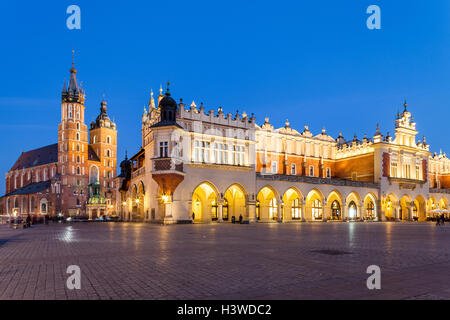 Krakow - Poland - April 22.  Evening view of Mariacki Church and Hall with markets inside the hall. People walks on old square. Stock Photo