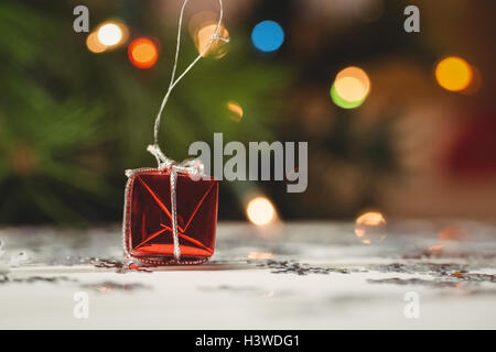 Small wrapped gift box and snowflake scattered on wooden table Stock Photo